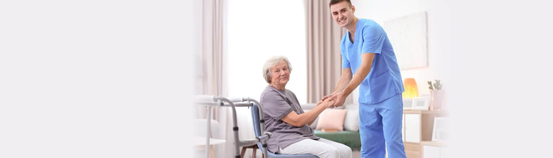 Senior woman walking with assistance of young caregiver
